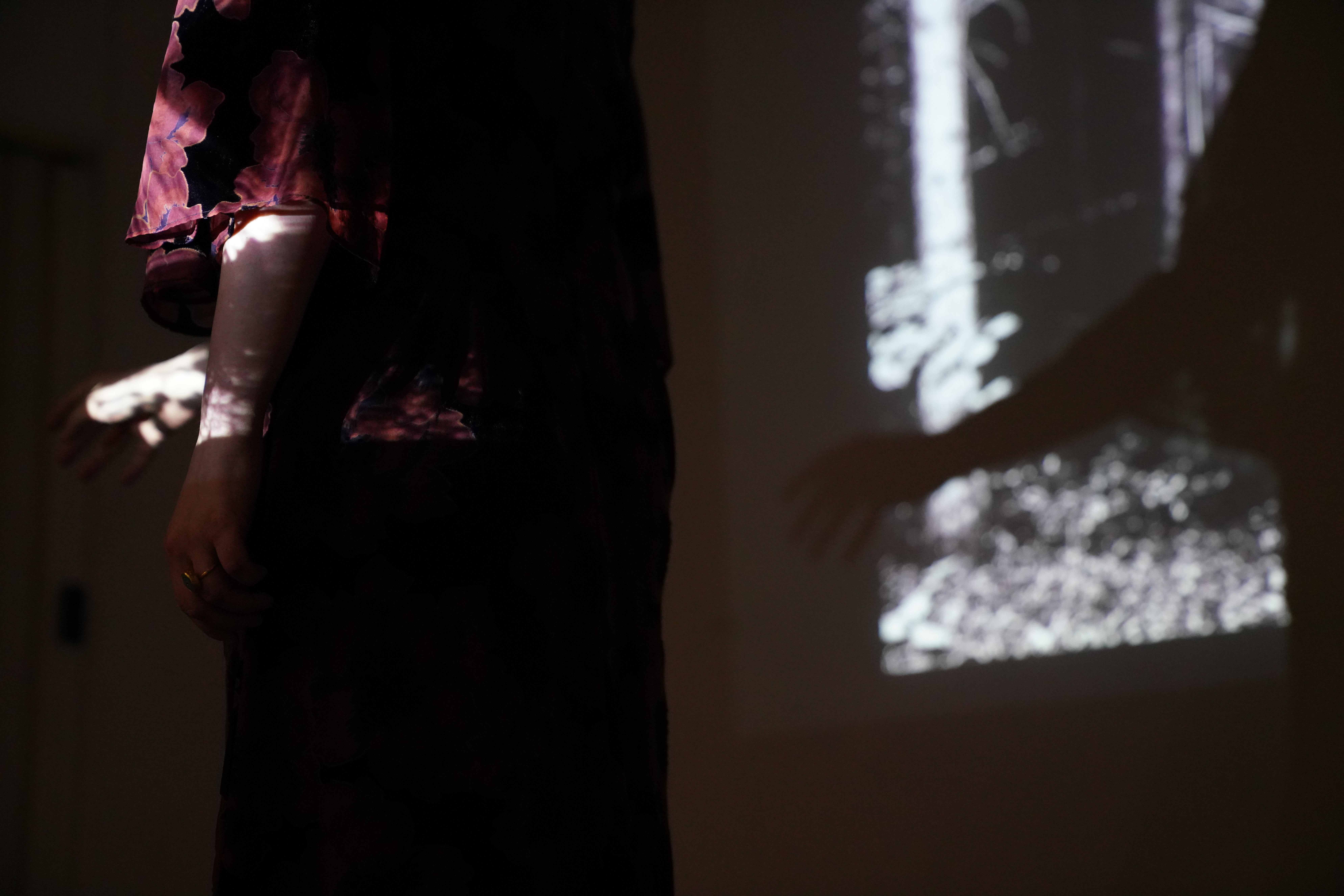 Performer silhouetted against projected graphic marks